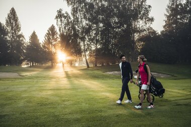 Paar beim Golfspielen am Morgen