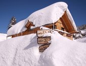Außenansicht der Hagan Lodge Altaussee im Winter mit Wegweiser