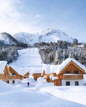 Skipiste und Außenansicht der Hagan Lodge Altaussee im Winter