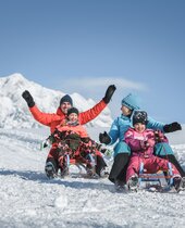 Familie beim Rodeln im Skigebiet Hochkönig