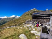 Wanderer rasten bei einer Osttiroler Hütte