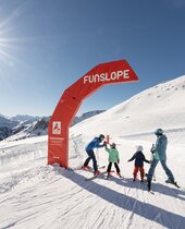 Familie beim Skifahren auf der Funslope